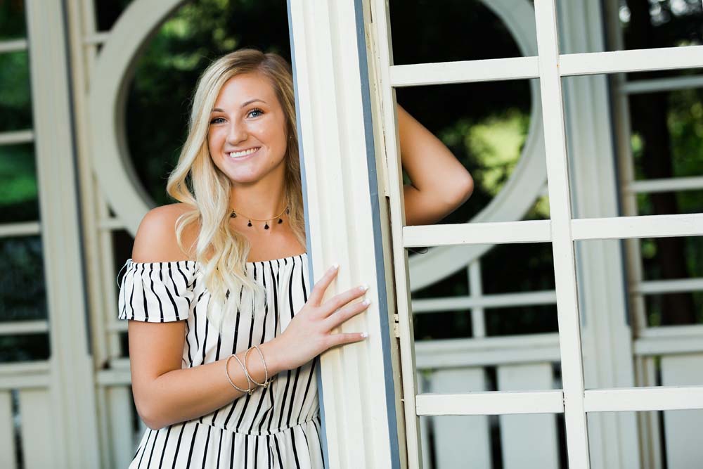 a young blonde woman poses for senior photos